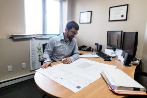 Homme assis à un bureau consultant un certificat de localisation