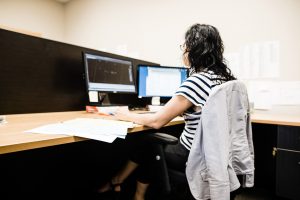 Femme asssise devant un écran d'ordinateur