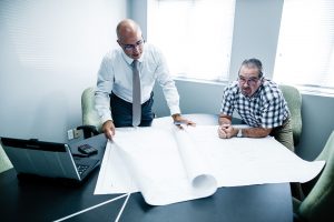 Deux géomètres regardant un plan d'implantation