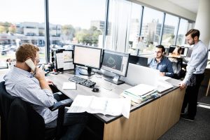 3 hommes à des bureaux de travail