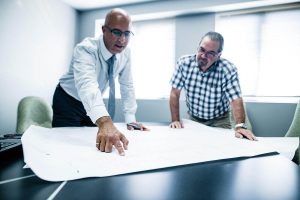 Deux géomètres consultant un plan de Denicourt
