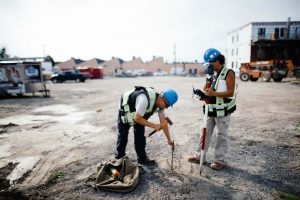 Deux travailleurs en arpentage qui pique un terrain